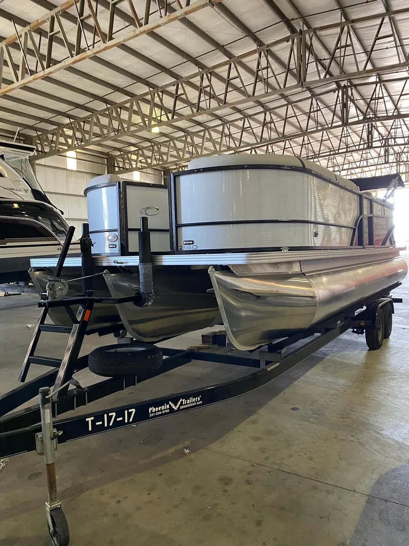 Slide: The Image of 2023 Crest Classic DLX 240 pontoon boat in a warehouse setting. - 11