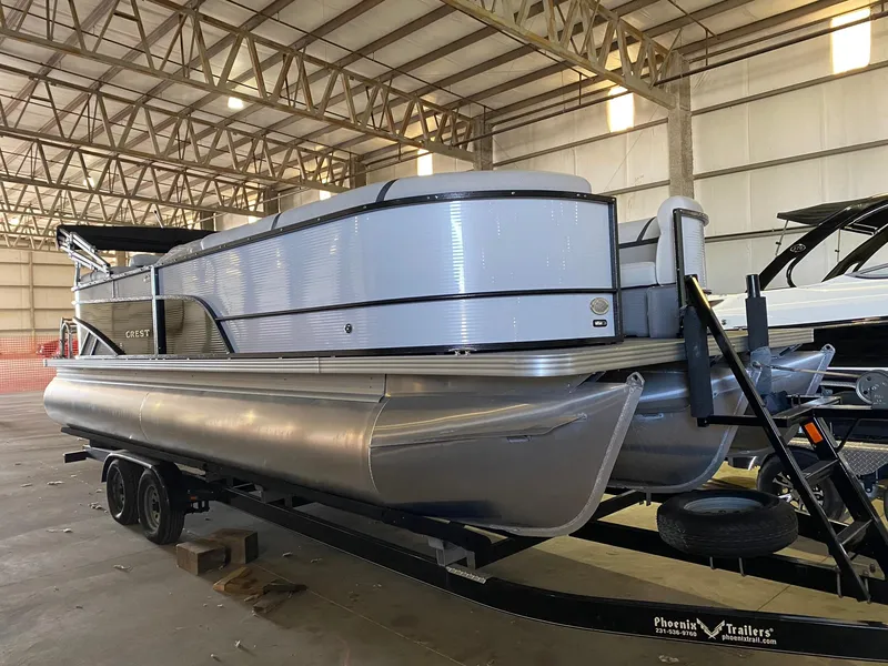 Slide: The Image of 2023 Crest Classic DLX 240 pontoon boat in a warehouse setting. - 5