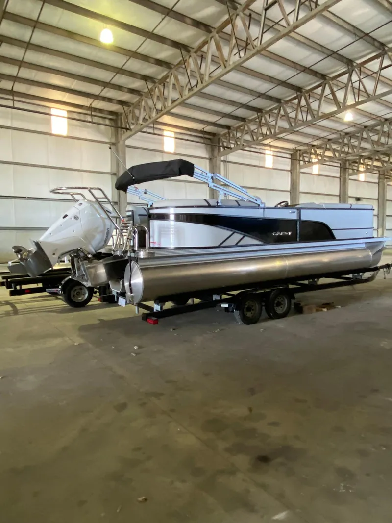 Slide: The Image of 2023 Crest Classic DLX 240 pontoon boat in a spacious indoor storage facility. - 6