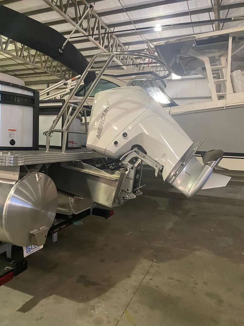 Slide: The Image of 2023 Crest Classic DLX 240 boat in a storage facility, showcasing its motor and sleek design. - 9