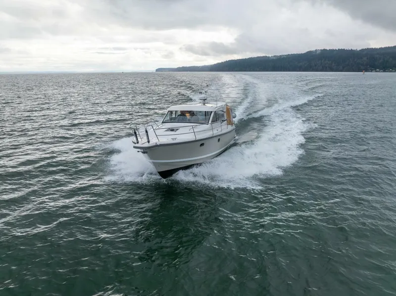 Slide: The Image of 2019 Nimbus 365 Coupe cruising on open water under cloudy skies. - 6