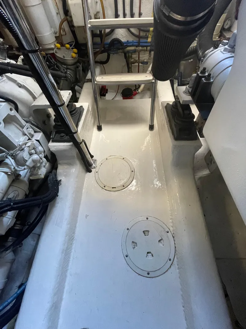 Slide: The Image of Engine room of 2005 Riviera 47 Open Flybridge Series II yacht, showing mechanical components and ladder. - 10