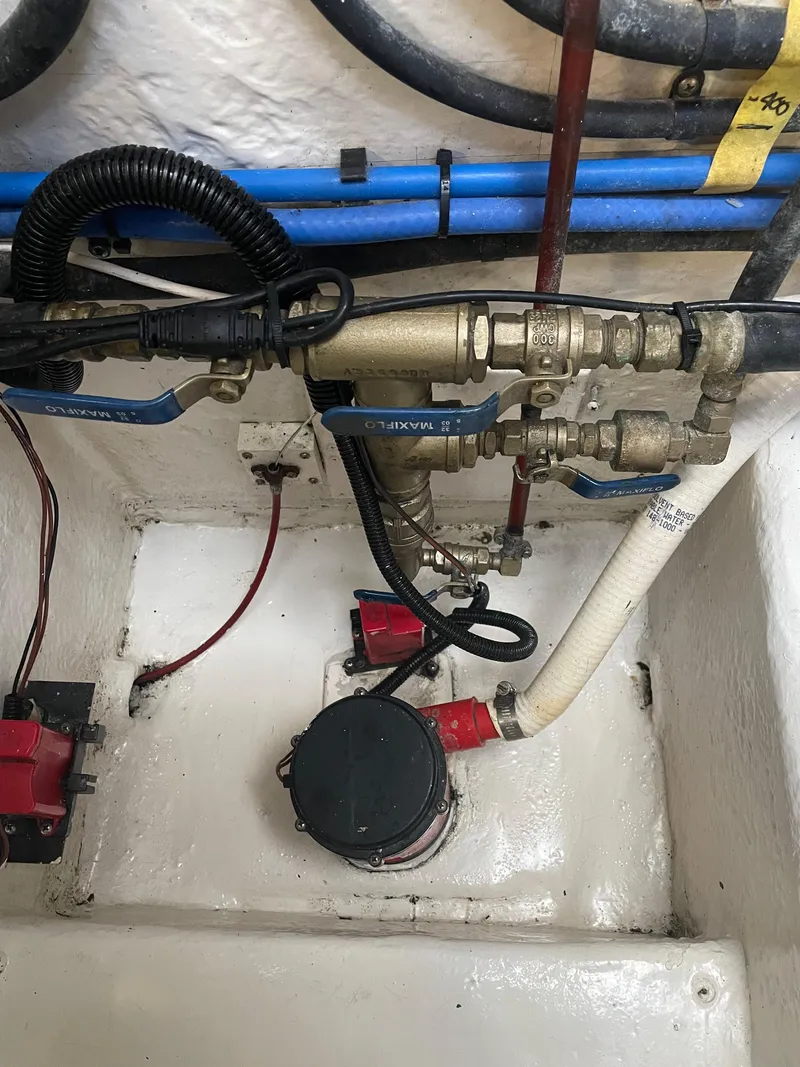 Slide: The Image of Engine room of a 2005 Riviera 47 Open Flybridge Series II with visible plumbing and wiring. - 12