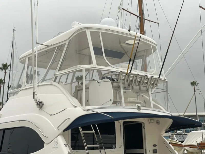 Slide: The Image of 2005 Riviera 47 Open Flybridge Series II yacht with enclosed flybridge, docked at marina. - 21