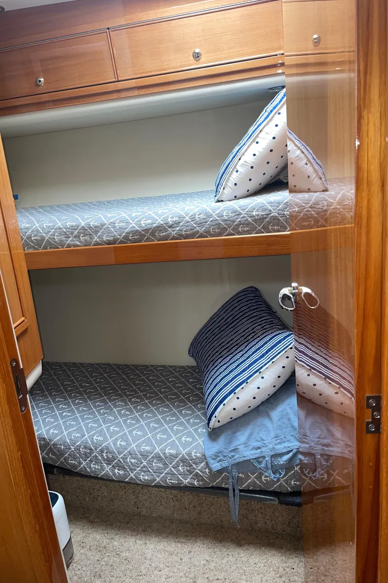 Slide: The Image of 2005 Riviera 47 Open Flybridge Series II cabin with bunk beds and cozy bedding. - 33