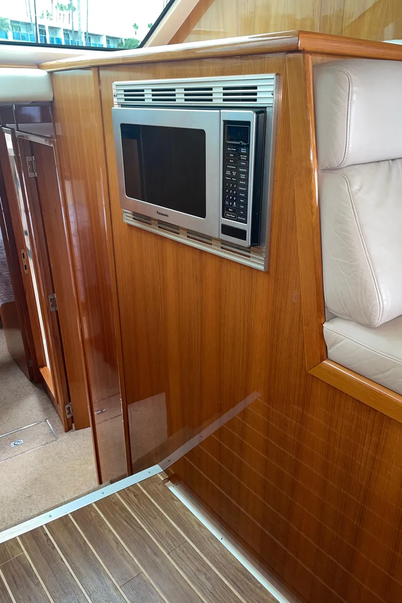 Slide: The Image of 2005 Riviera 47 Open Flybridge Series II interior with built-in microwave and wooden paneling. - 34