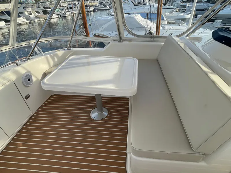 Slide: The Image of 2005 Riviera 47 Open Flybridge Series II interior with seating and table, docked at marina. - 42