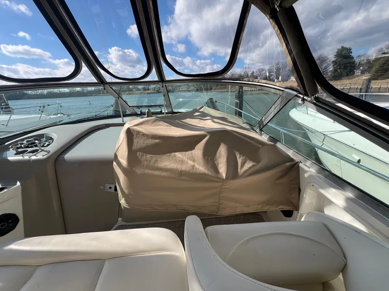 Slide: The Image of 2001 Sea Ray 340 Sundancer cockpit with covered controls, clear skies, and water view. - 11