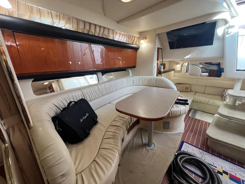Slide: The Image of Interior of 2001 Sea Ray 340 Sundancer yacht with plush seating and wooden cabinetry. - 22
