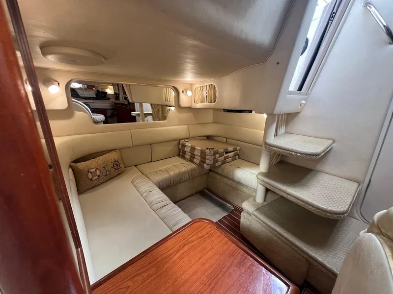 Slide: The Image of 2001 Sea Ray 340 Sundancer cabin interior with beige seating and wooden table. - 24