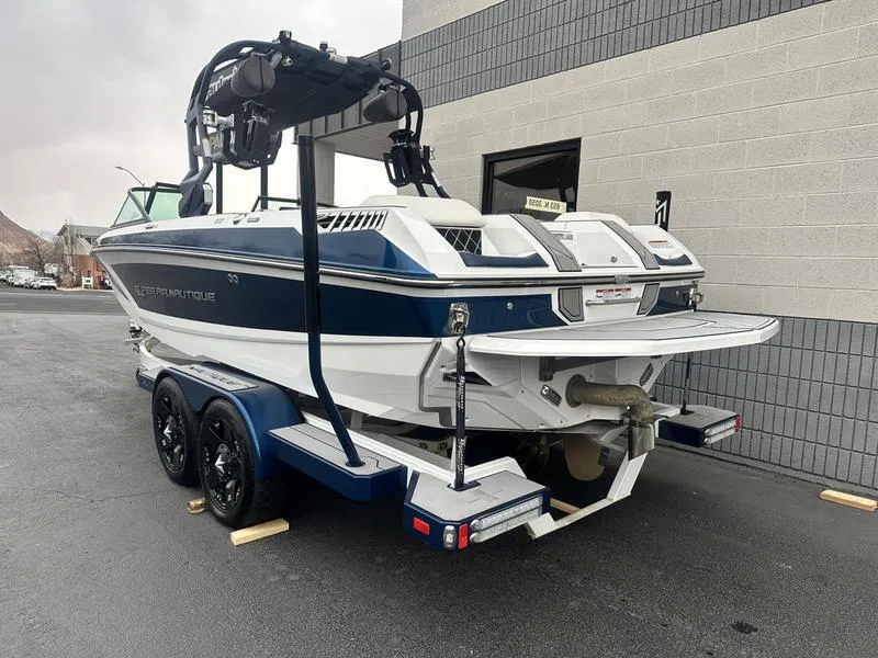 Slide: The Image of 2019 Nautique Super Air Nautique GS22 boat on a trailer, parked outside a building. - 4