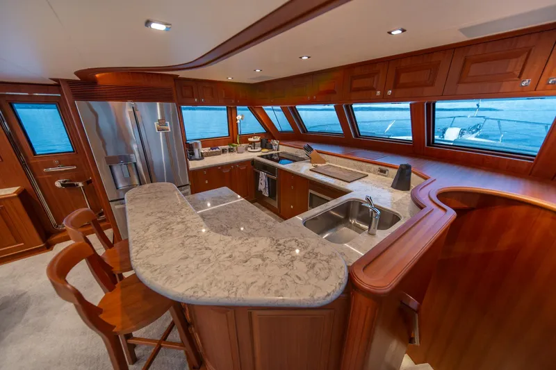 Slide: The Image of Luxurious kitchen interior of 2022 Hampton Endurance 750 LRC yacht with wooden cabinetry and marble countertops. - 15