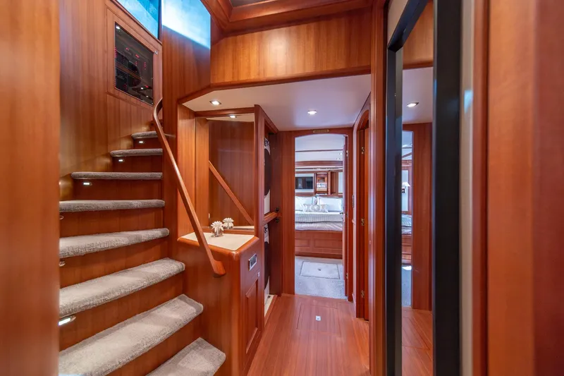 Slide: The Image of Interior of 2022 Hampton Endurance 750 LRC yacht, featuring elegant wood paneling and staircase. - 16