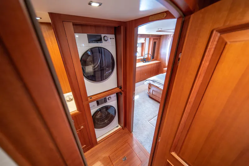 Slide: The Image of Laundry area inside 2022 Hampton Endurance 750 LRC yacht, featuring stacked washer and dryer. - 18