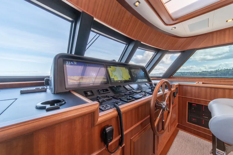 Slide: The Image of 2022 Hampton Endurance 750 LRC yacht helm with navigation screens and wooden steering wheel. - 37