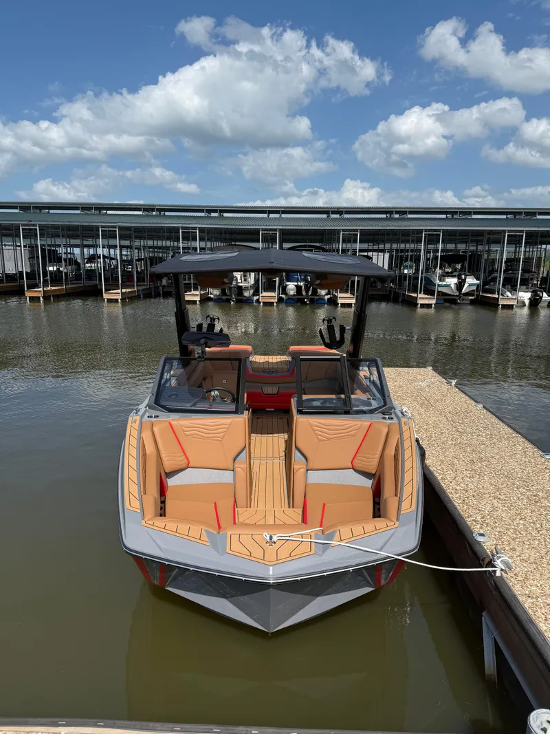 Slide: The Image of 2025 Nautique Super Air Nautique G23 boat docked under a blue sky. - 3