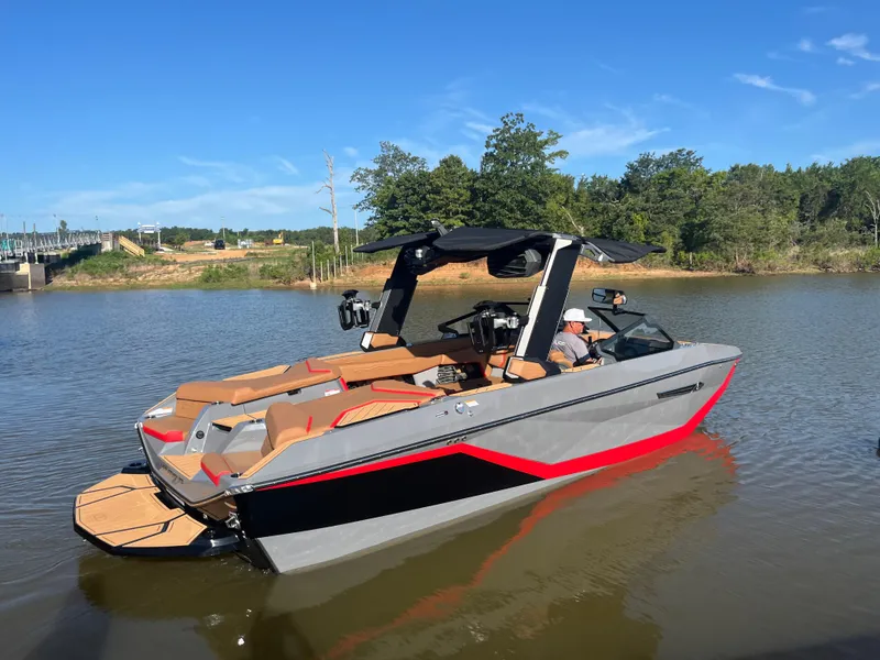 Slide: The Image of 2025 Nautique Super Air Nautique G23 boat on a calm lake under clear blue skies. - 5