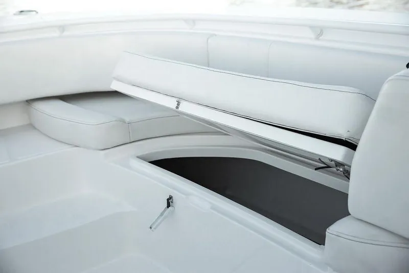 Slide: The Image of 2024 Fountain 34 CC boat interior with open storage compartment and white seating. - 11
