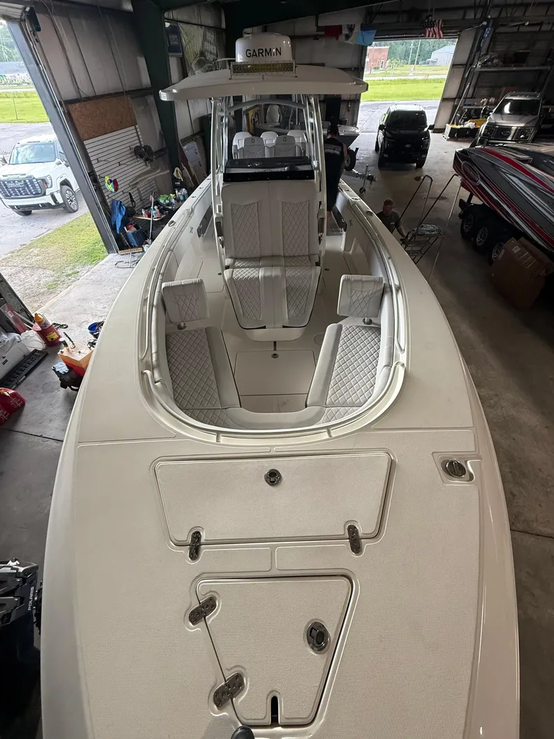 Slide: The Image of 2023 Fountain 34 CC boat in a garage, showcasing spacious deck and seating. - 18