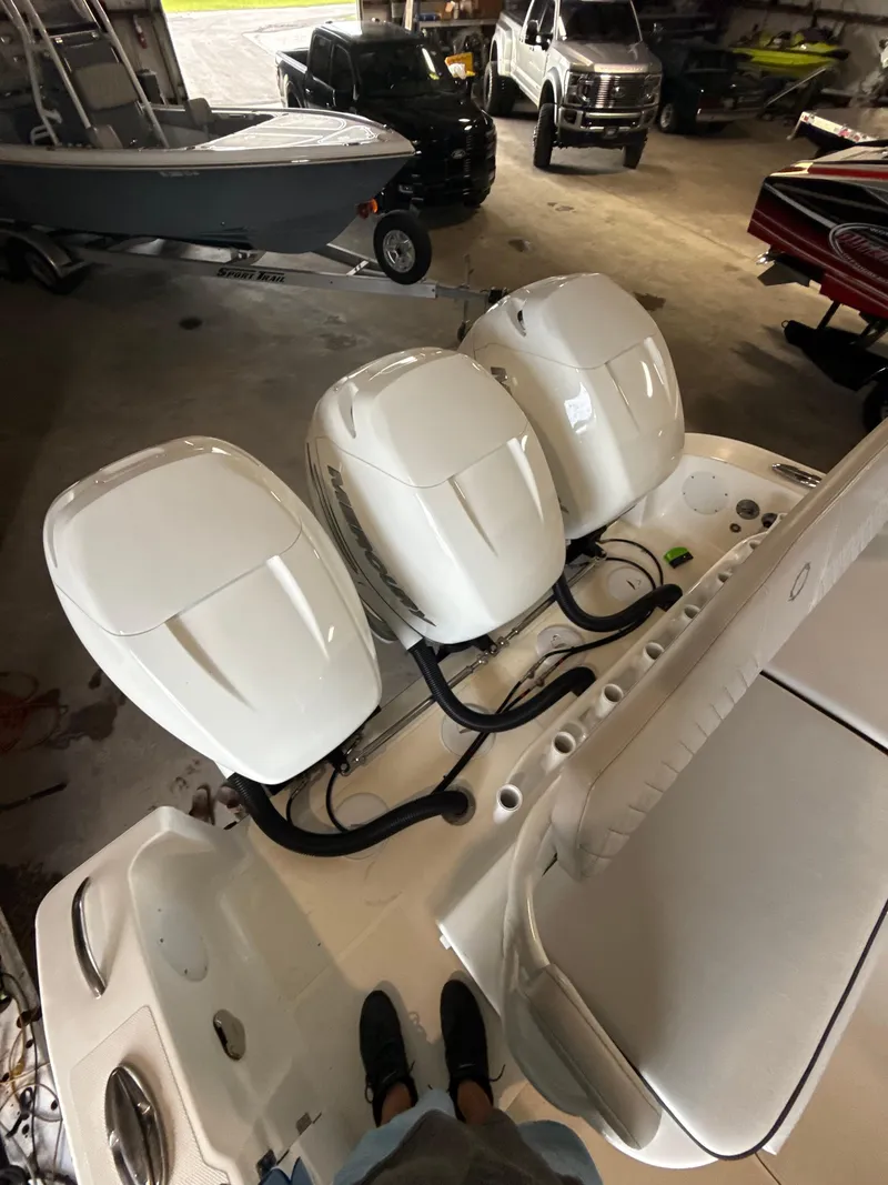 Slide: The Image of 2023 Fountain 34 CC boat with triple outboard engines in a garage setting. - 21