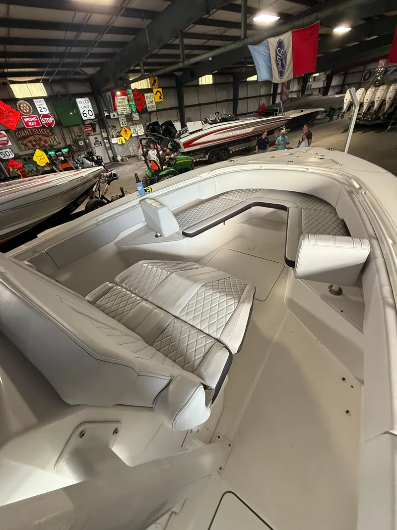 Slide: The Image of 2023 Fountain 34 CC boat interior with white seating in a showroom. - 24
