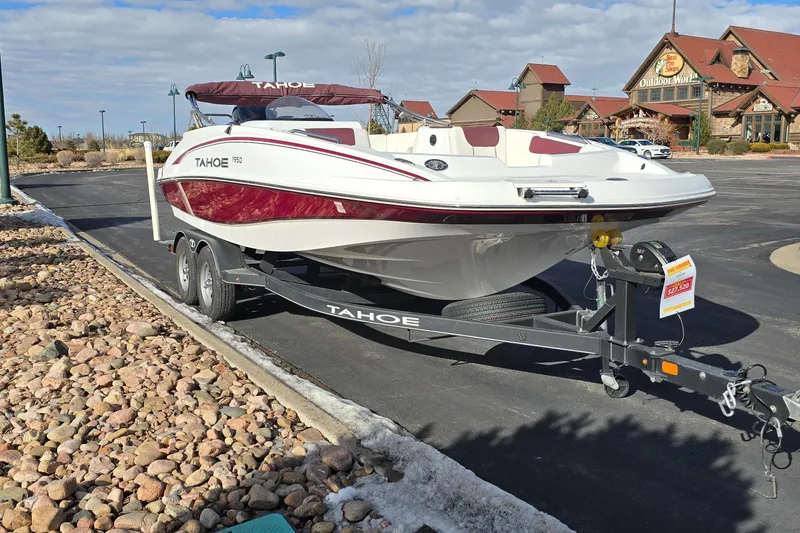 Slide: The Image of 2020 Tahoe 1950 boat on trailer in parking lot, clear sky background. - 2