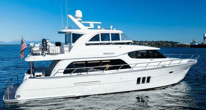 Slide: The Image of 2017 Regency P65 yacht cruising on open water under clear blue skies. - 2