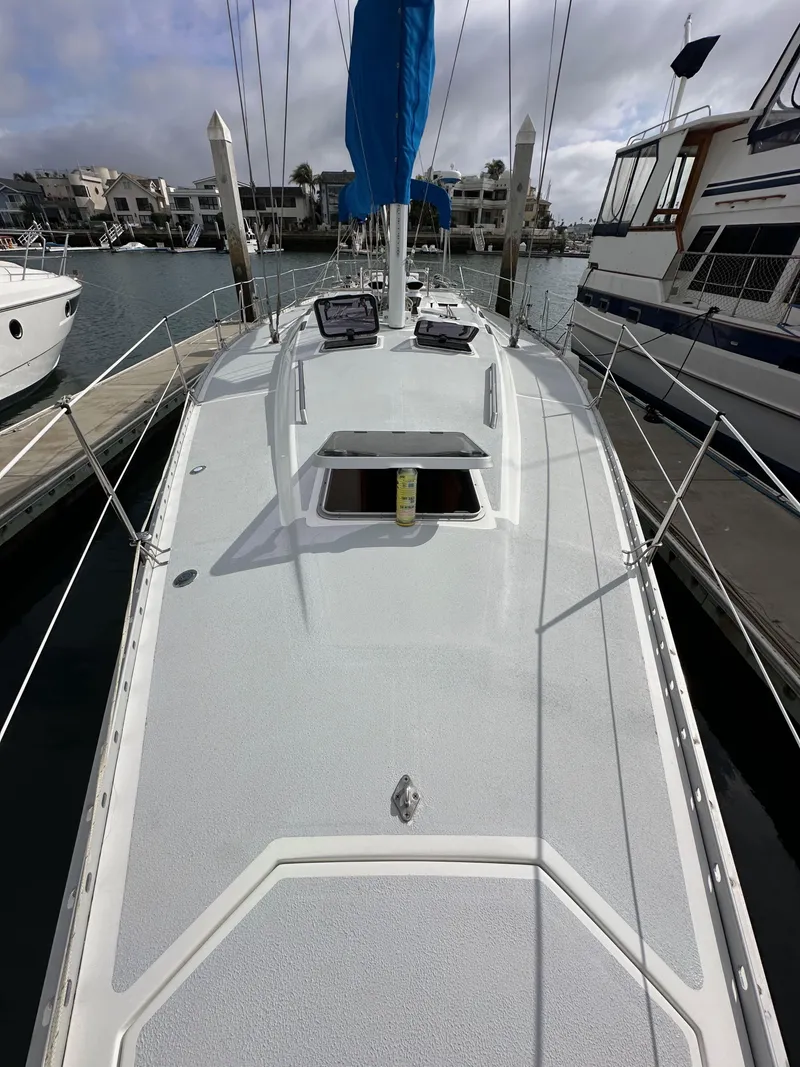 Slide: The Image of 1987 Hunter Legend 45 sailboat docked, showcasing sleek deck design and marina surroundings. - 15