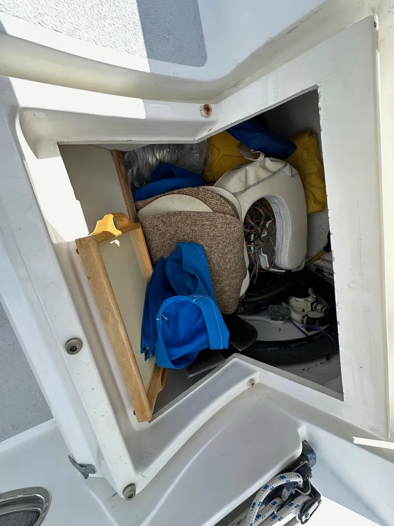 Slide: The Image of Storage compartment on a 1987 Hunter Legend 45 sailboat, filled with various boating equipment. - 24