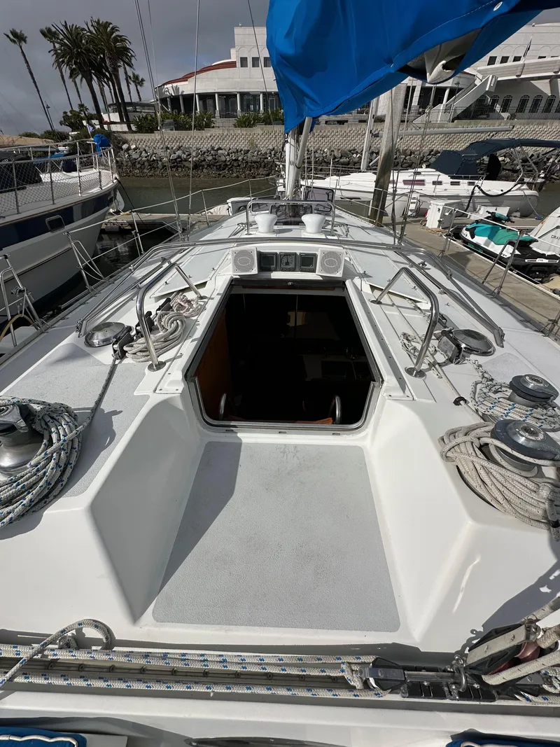 Slide: The Image of 1987 Hunter Legend 45 sailboat deck with ropes and open hatch in marina. - 25