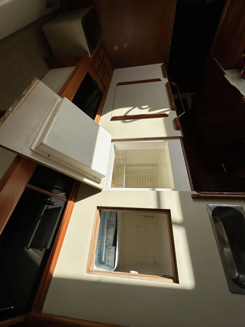Slide: The Image of Interior view of 1987 Hunter Legend 45 sailboat kitchen with open storage compartments. - 30