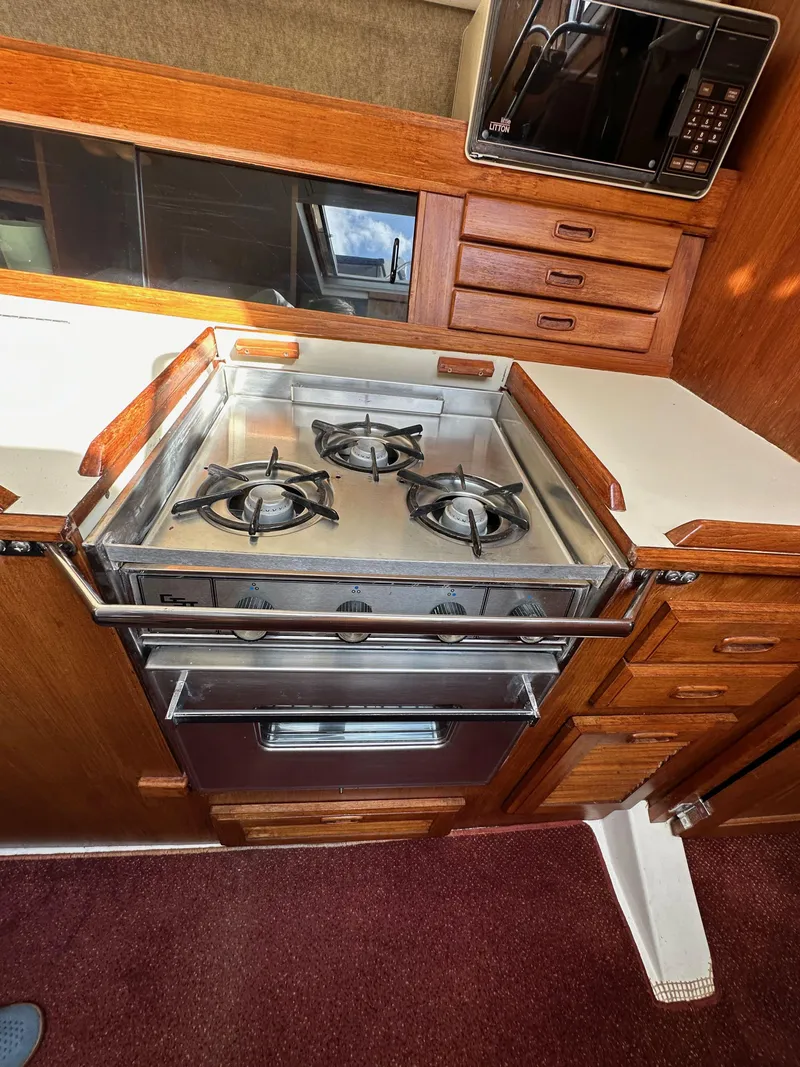 Slide: The Image of 1987 Hunter Legend 45 yacht kitchen with stove, oven, and wooden cabinetry. - 33