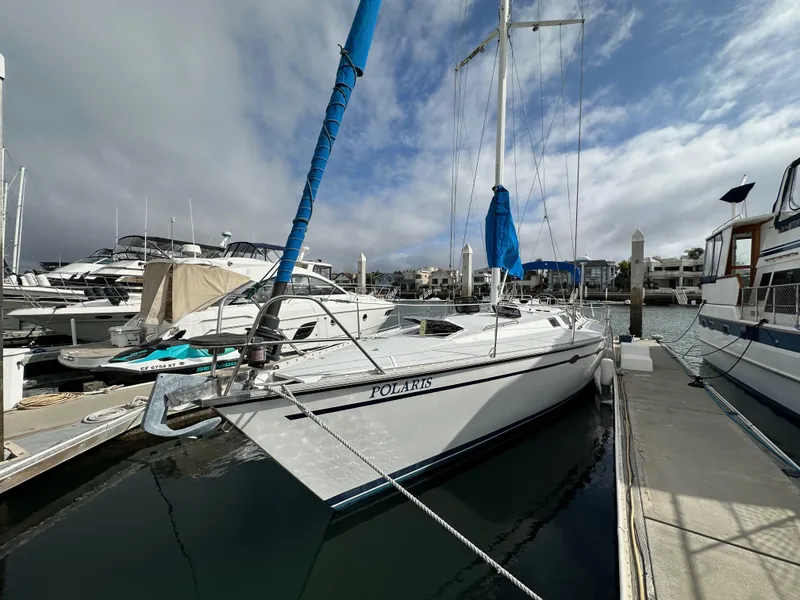 Slide: The Image of 1987 Hunter Legend 45 sailboat docked at marina under cloudy sky. - 4