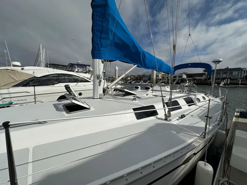 Slide: The Image of 1987 Hunter Legend 45 sailboat with blue sails docked at a marina. - 6