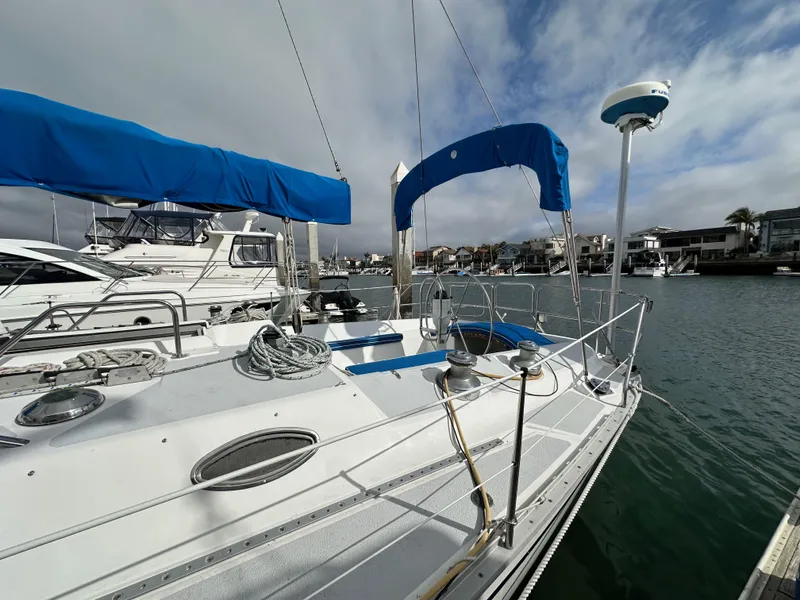 Slide: The Image of 1987 Hunter Legend 45 sailboat docked in a marina with blue covers. - 8