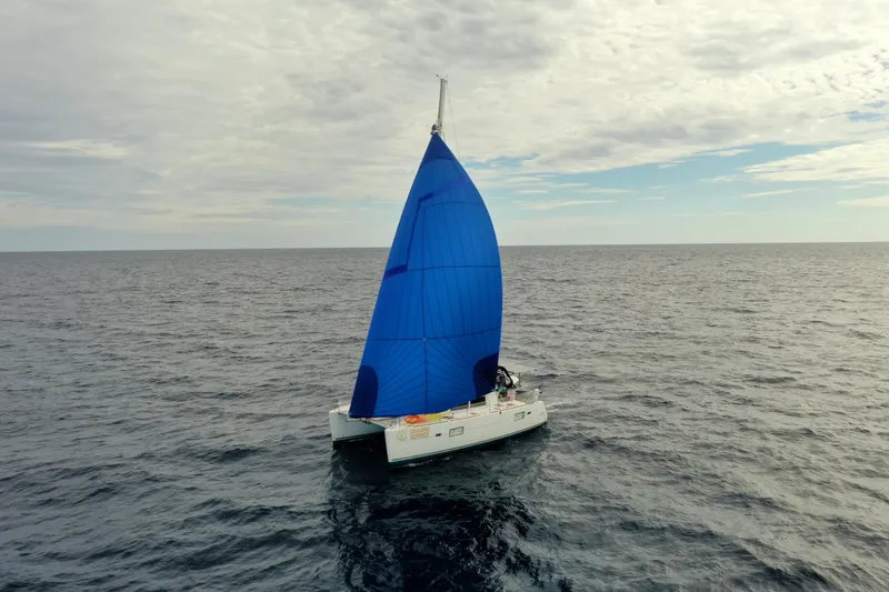 Slide: The Image of Sailing catamaran Lagoon 400 (2012) with blue sail on open sea under cloudy sky. - 1