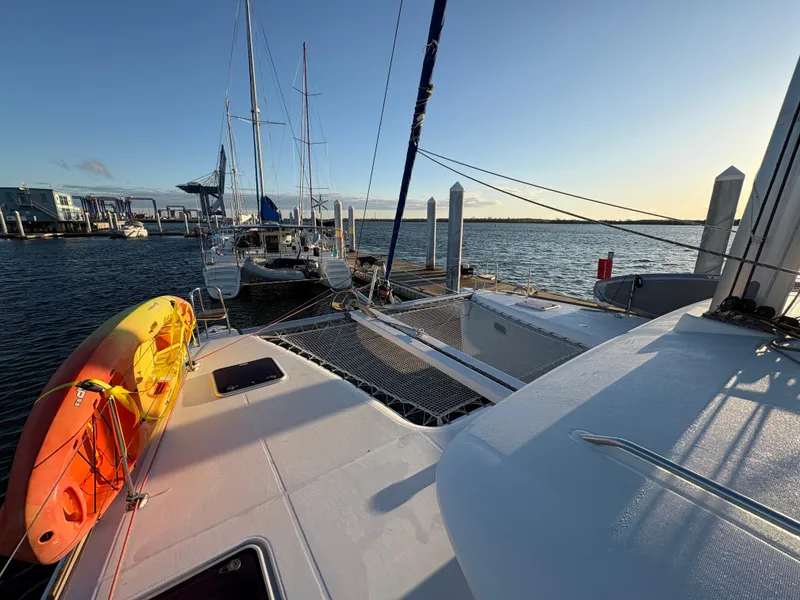Slide: The Image of 2012 Lagoon 400 catamaran docked at marina with kayak on deck, sunset view. - 29