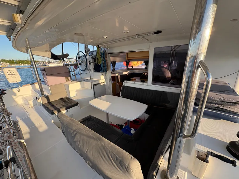 Slide: The Image of 2012 Lagoon 400 yacht interior with seating, table, and helm, docked by the water. - 37