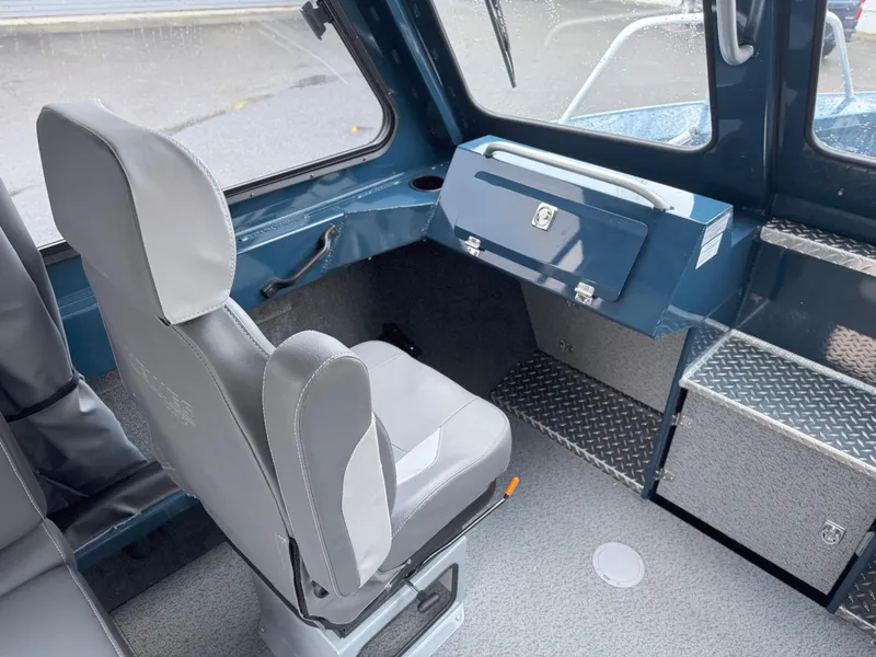 Slide: The Image of 2025 Hewescraft 220 Ocean Pro interior with gray seating and storage compartments. - 7