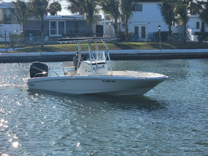 Slide: The Image of 2013 Boston Whaler 230 Dauntless boat on water, near waterfront homes. - 1
