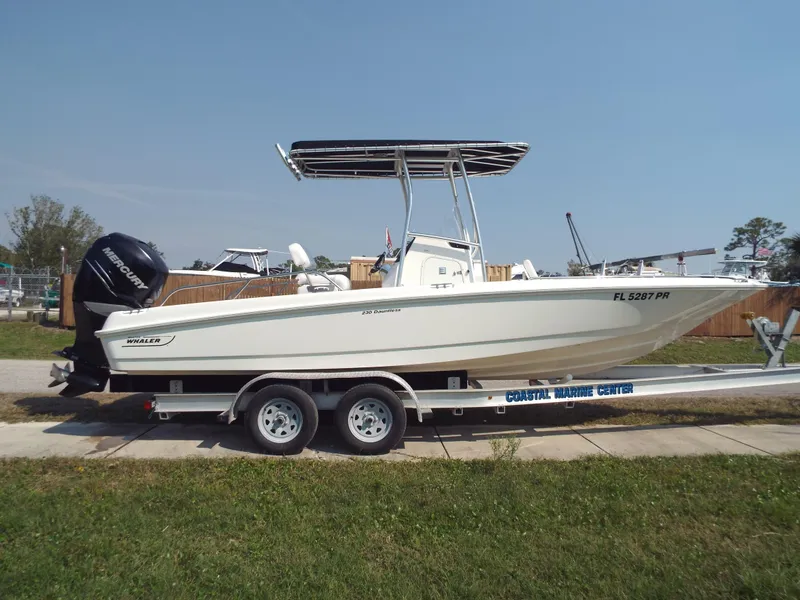 Slide: The Image of 2013 Boston Whaler 230 Dauntless boat on trailer, side view, outdoors. - 10