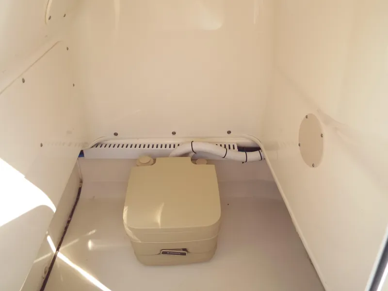 Slide: The Image of 2013 Boston Whaler 230 Dauntless interior storage compartment with portable toilet. - 8