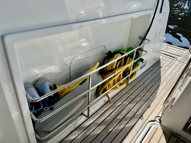 Slide: The Image of 2022 Jeanneau NC 895 Sport boat storage with shoes and coiled hoses on deck. - 12