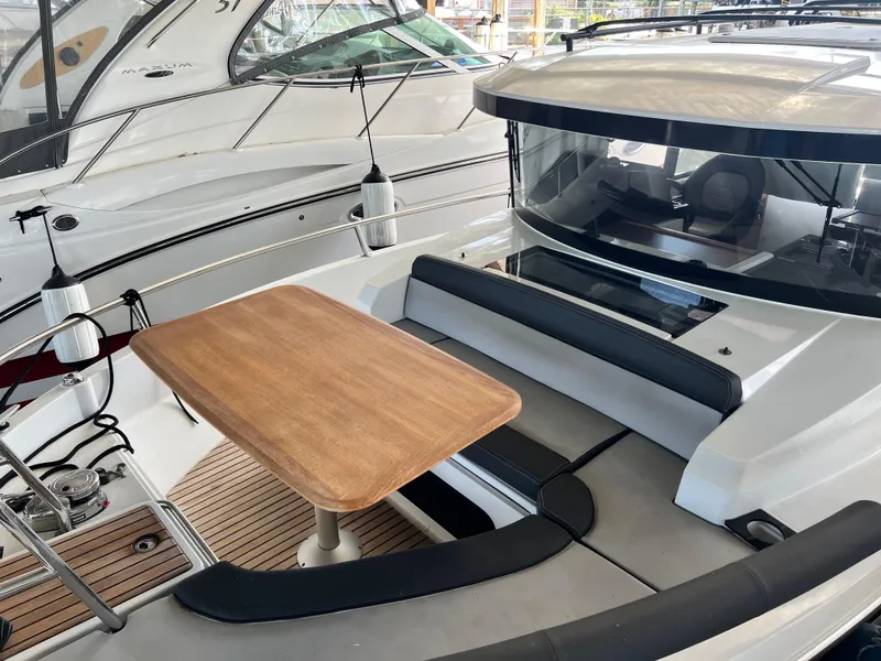 Slide: The Image of 2022 Jeanneau NC 895 Sport boat with outdoor seating and wooden table. - 3