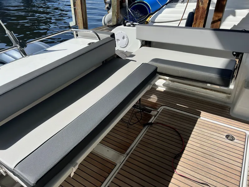 Slide: The Image of 2022 Jeanneau NC 895 Sport boat interior with cushioned seating and wooden deck. - 9