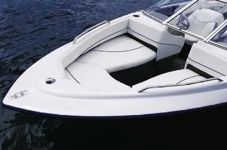 Slide: The Image of 2004 Bayliner International 195 Classic boat on water, featuring sleek white seating and design. - 13