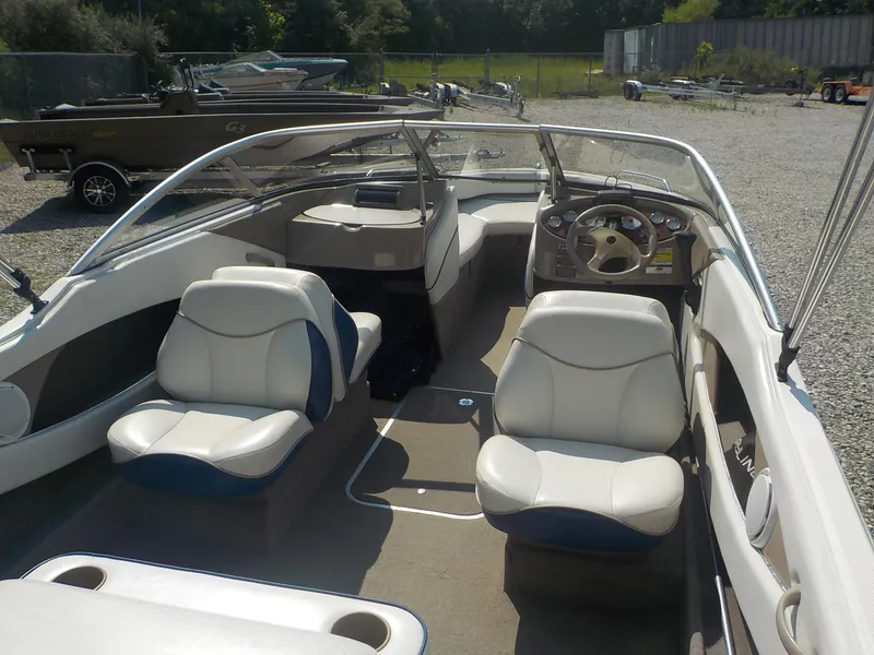 Slide: The Image of 2004 Bayliner International 195 Classic boat interior with white seating and steering console. - 18