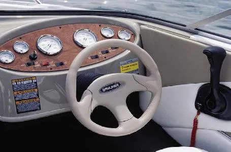 Slide: The Image of 2004 Bayliner International 195 Classic boat dashboard with steering wheel and gauges. - 5