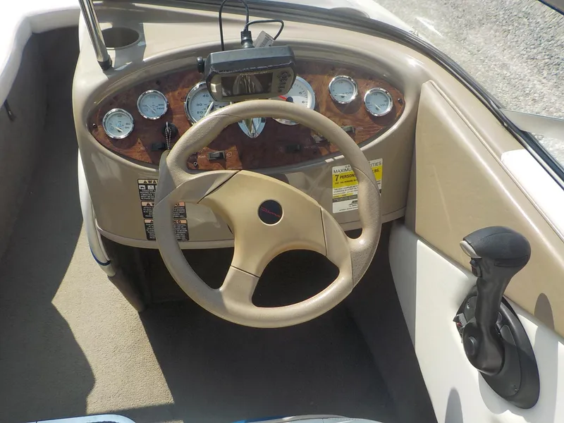 Slide: The Image of 2004 Bayliner 195 Classic boat dashboard with steering wheel and gauges. - 9