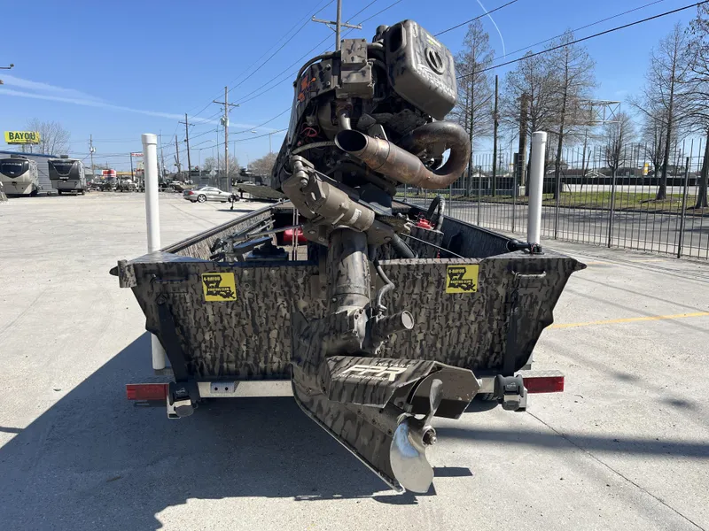 Slide: The Image of 2023 Pro-Drive SBX 1854 Stick Drive boat with camo design, parked outdoors. - 12